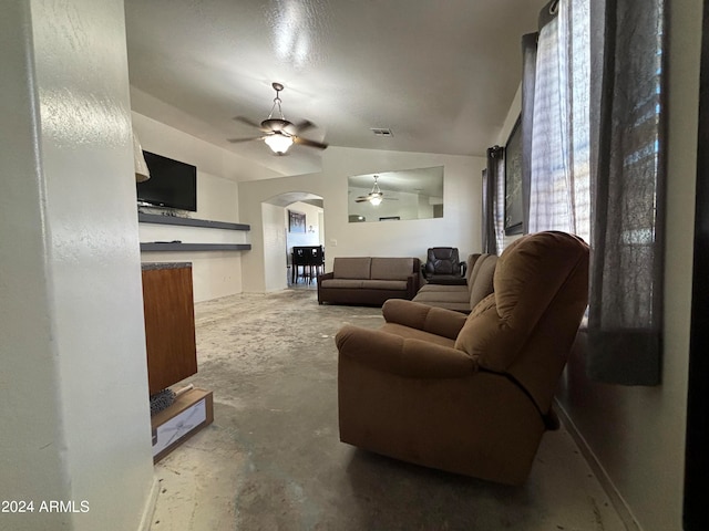 living room with lofted ceiling, concrete flooring, and ceiling fan