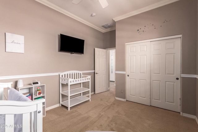 carpeted bedroom with crown molding, a closet, baseboards, and ceiling fan