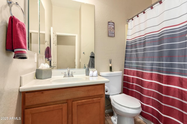 full bathroom with toilet, vanity, a shower with curtain, and a textured wall