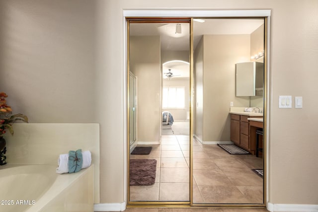 bathroom with vanity, a garden tub, baseboards, tile patterned flooring, and ceiling fan