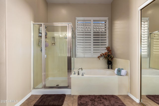 bathroom with a garden tub, a stall shower, tile patterned floors, and baseboards
