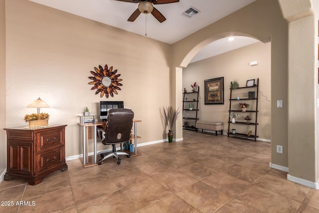 office featuring arched walkways, a ceiling fan, and baseboards