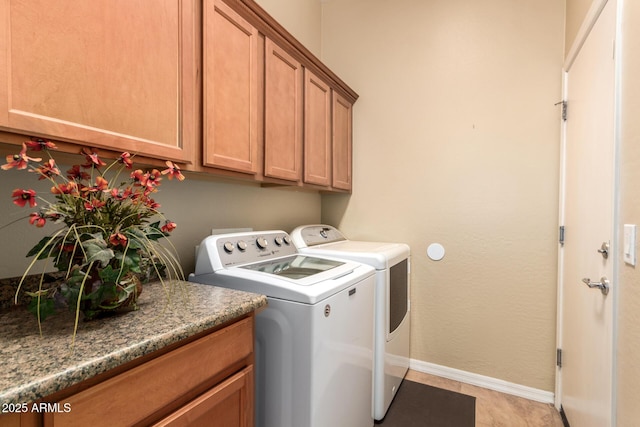 laundry room with separate washer and dryer, cabinet space, and baseboards