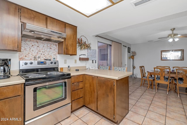 kitchen featuring stainless steel electric range, ceiling fan, light tile patterned floors, kitchen peninsula, and extractor fan