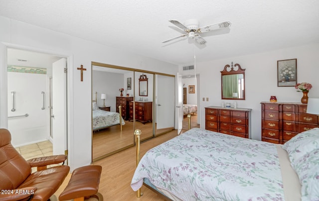 bedroom featuring connected bathroom, ceiling fan, light hardwood / wood-style floors, and a textured ceiling