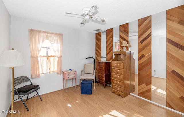 sitting room with hardwood / wood-style flooring and ceiling fan