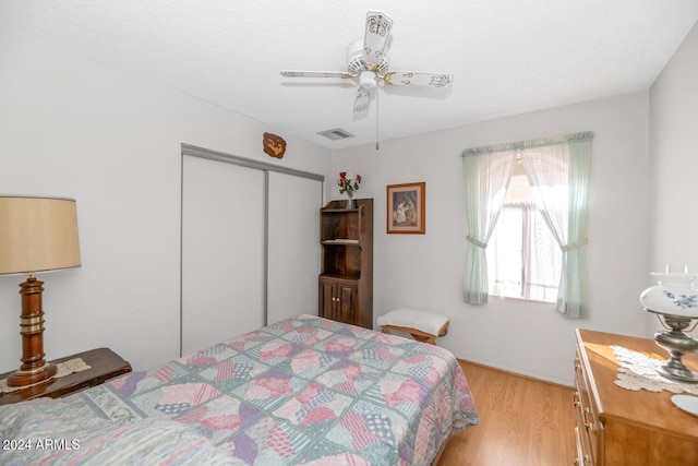 bedroom with ceiling fan, a closet, and light hardwood / wood-style flooring