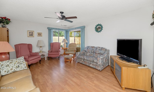 living room with ceiling fan, hardwood / wood-style floors, and a textured ceiling