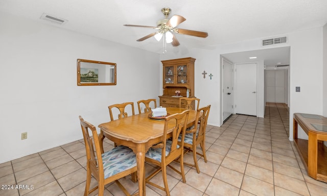 dining space with ceiling fan, light tile patterned flooring, and a textured ceiling