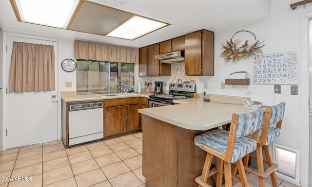 kitchen with dishwasher, a kitchen breakfast bar, electric stove, sink, and kitchen peninsula