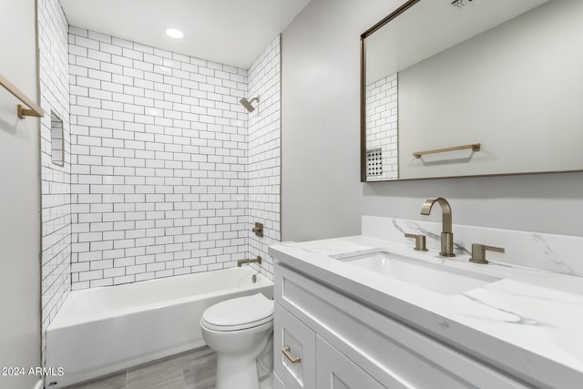 full bathroom featuring tiled shower / bath combo, vanity, and toilet