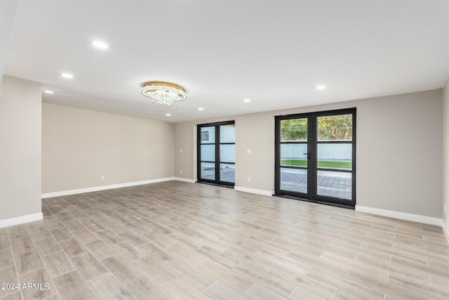 unfurnished room with light hardwood / wood-style floors and french doors