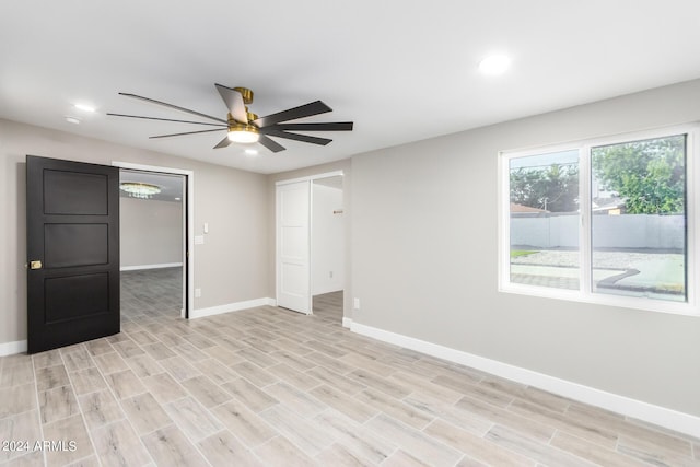 empty room with ceiling fan and light wood-type flooring