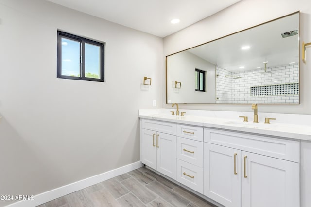 bathroom featuring hardwood / wood-style flooring, vanity, and a shower