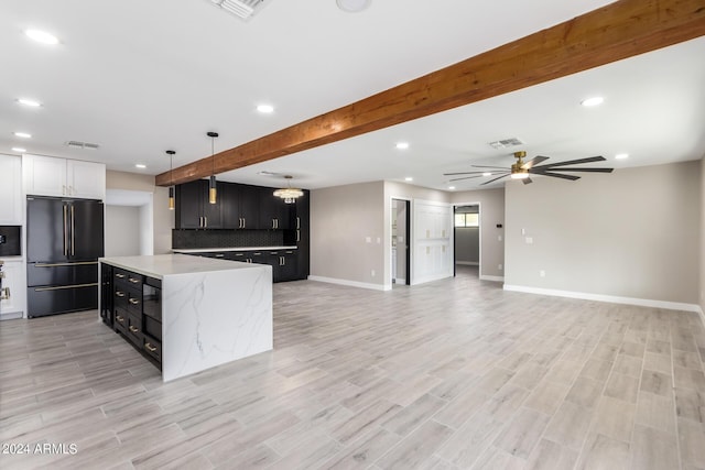 kitchen with pendant lighting, tasteful backsplash, a center island, high quality fridge, and beamed ceiling