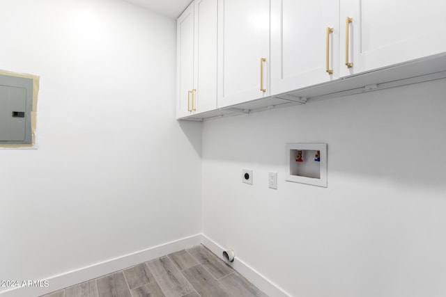 clothes washing area with cabinets, light hardwood / wood-style flooring, electric panel, hookup for a washing machine, and hookup for an electric dryer