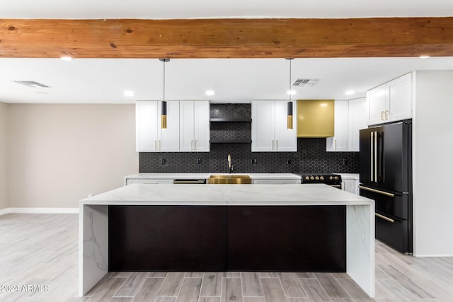 kitchen with pendant lighting, light stone countertops, a kitchen island, and black appliances