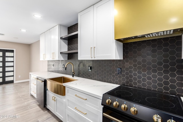 kitchen with sink, white cabinetry, electric range oven, stainless steel dishwasher, and backsplash