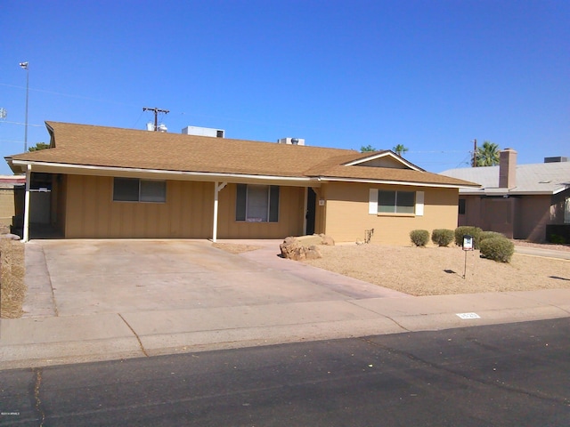 single story home featuring driveway and a shingled roof