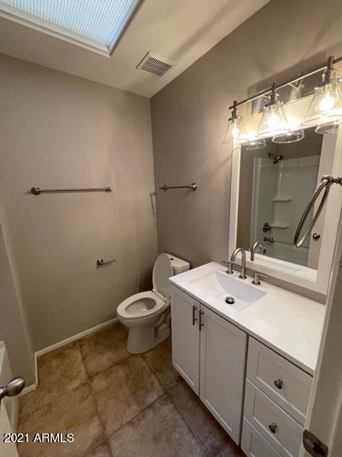 full bath with baseboards, visible vents, a shower, toilet, and vanity