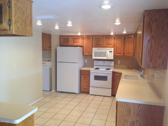 kitchen with light tile patterned flooring, white appliances, a sink, light countertops, and washer / clothes dryer