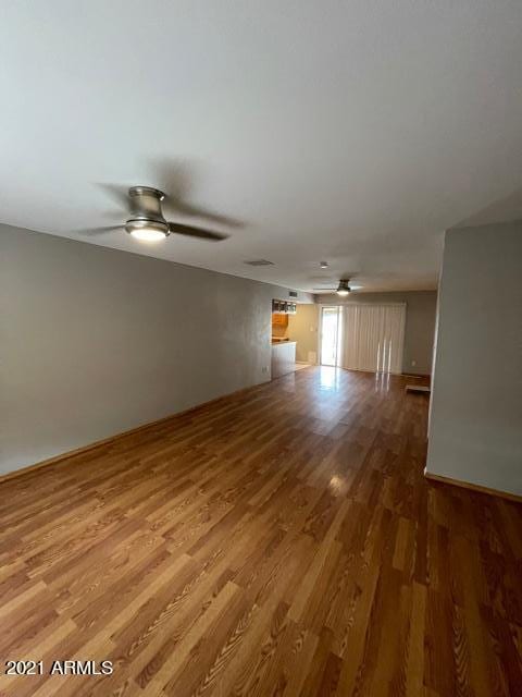 unfurnished living room featuring ceiling fan and wood finished floors