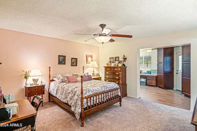 bedroom featuring ceiling fan, a textured ceiling, and light wood-type flooring