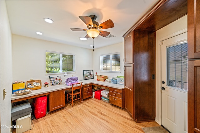 office area featuring ceiling fan, built in desk, and light hardwood / wood-style floors