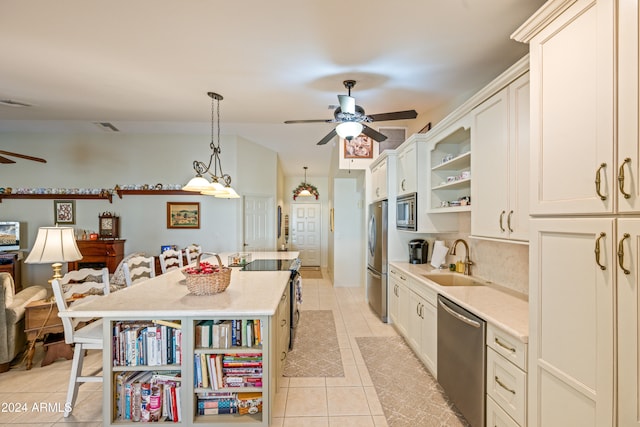 kitchen featuring appliances with stainless steel finishes, sink, a kitchen island, a breakfast bar area, and light tile patterned flooring