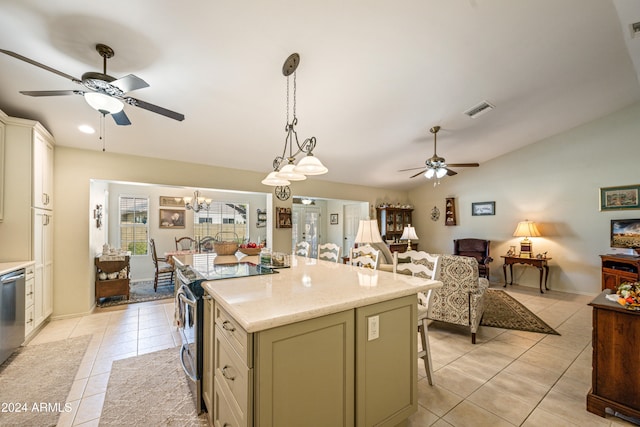 kitchen featuring a center island, a kitchen breakfast bar, light stone counters, decorative light fixtures, and light tile patterned floors