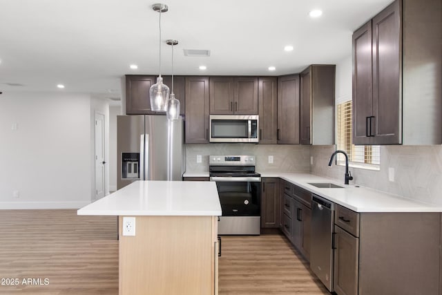2329 S Elm, Mesa, AZ 85202 - kitchen with stainless steel appliances, a sink, light wood-style flooring, decorative backsplash, and dark brown cabinetry
