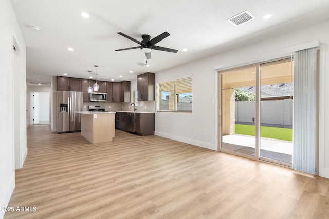 2329 S Elm, Mesa, AZ 85202 - kitchen featuring appliances with stainless steel finishes, baseboards, light countertops, a kitchen island, and dark brown cabinets