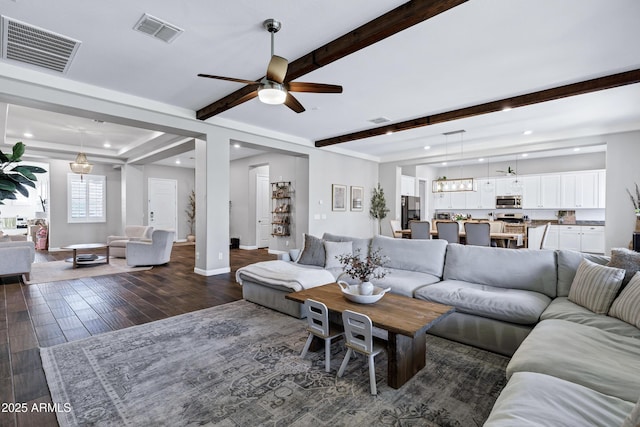 living room with visible vents, ceiling fan, and beam ceiling
