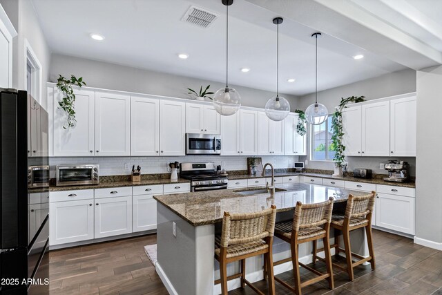 kitchen featuring dark wood finished floors, a toaster, appliances with stainless steel finishes, a sink, and visible vents