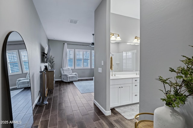 bathroom featuring visible vents, baseboards, wood finished floors, vanity, and a ceiling fan