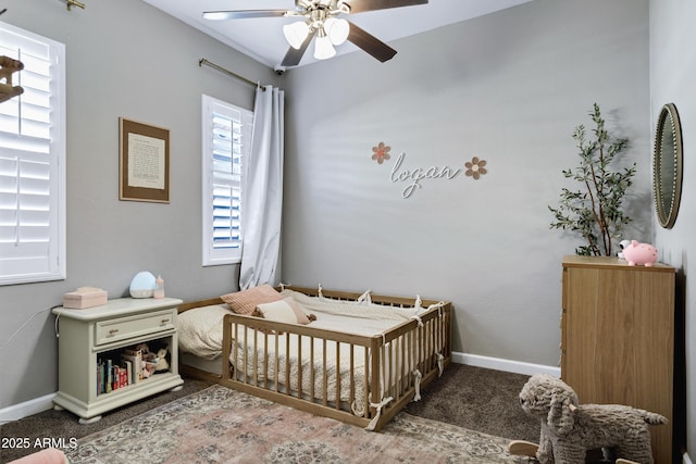 bedroom with a ceiling fan, carpet flooring, and baseboards