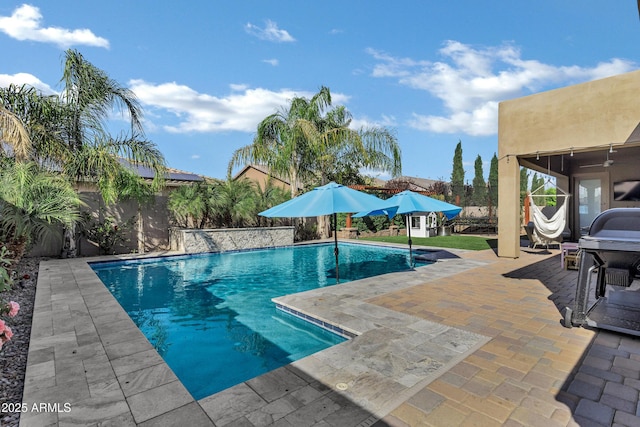 pool featuring a grill, a patio area, and a fenced backyard