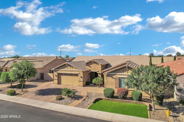 view of front of property featuring stucco siding, decorative driveway, an attached garage, and a tile roof
