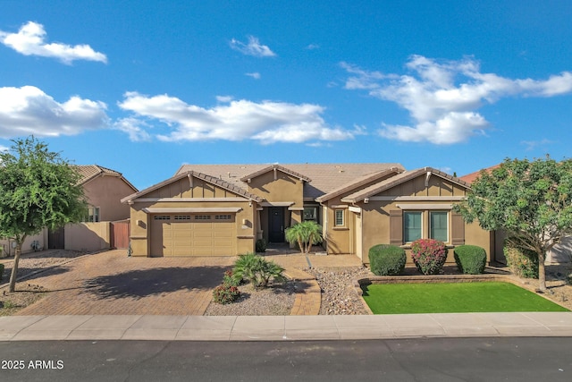 view of front of property featuring stucco siding, decorative driveway, a tiled roof, and an attached garage