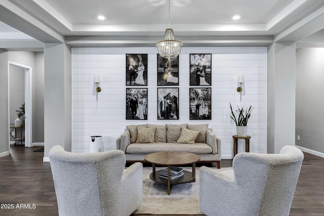 living room with a raised ceiling, a chandelier, baseboards, recessed lighting, and dark wood-type flooring