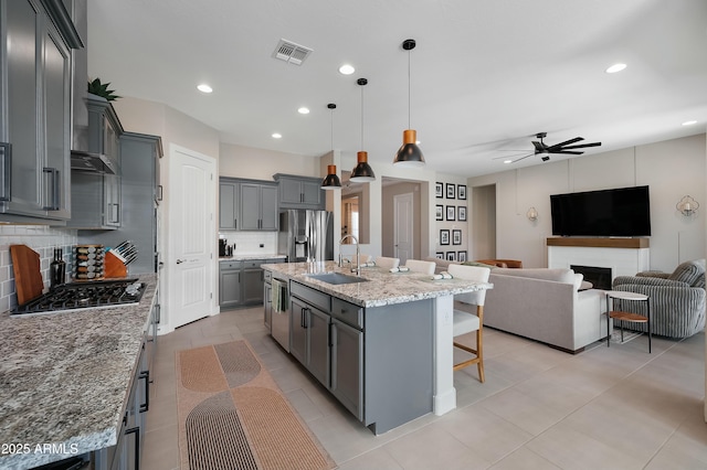 kitchen with appliances with stainless steel finishes, visible vents, a sink, and gray cabinetry