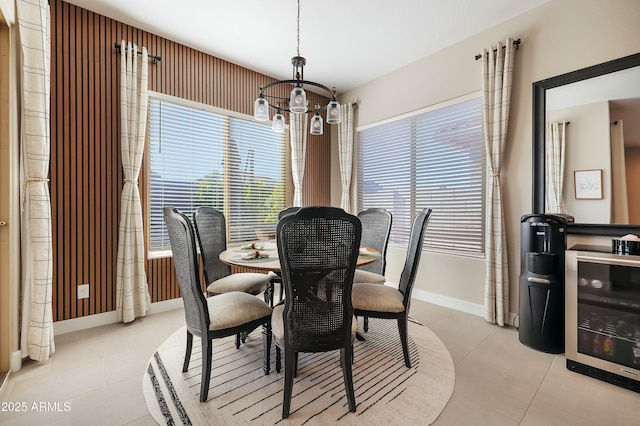 dining room featuring light tile patterned floors, baseboards, and an inviting chandelier