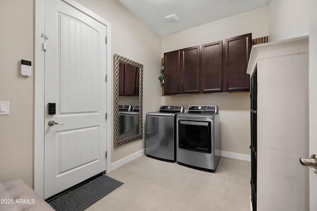 clothes washing area with cabinet space, visible vents, baseboards, and separate washer and dryer