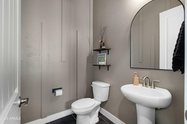 bathroom featuring baseboards, toilet, and tile patterned floors