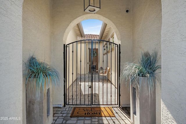 doorway to property featuring a gate and stucco siding