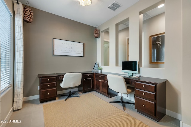 home office featuring light tile patterned floors, a wealth of natural light, visible vents, and baseboards