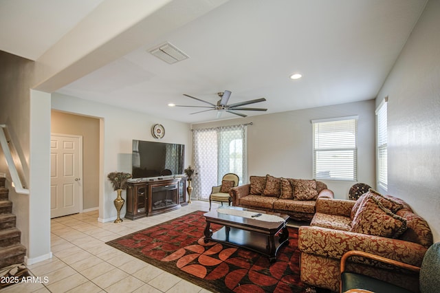living room featuring visible vents, stairway, light tile patterned floors, and a healthy amount of sunlight