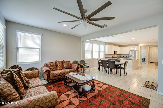 living room with baseboards, recessed lighting, light tile patterned floors, visible vents, and ceiling fan