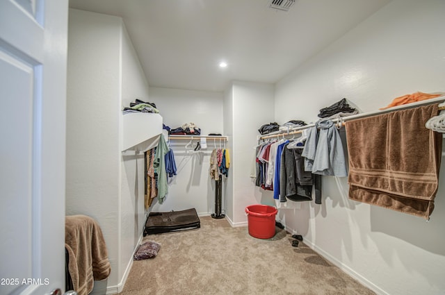 walk in closet featuring visible vents and carpet