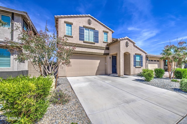 mediterranean / spanish-style house with concrete driveway, stucco siding, a tile roof, and a garage